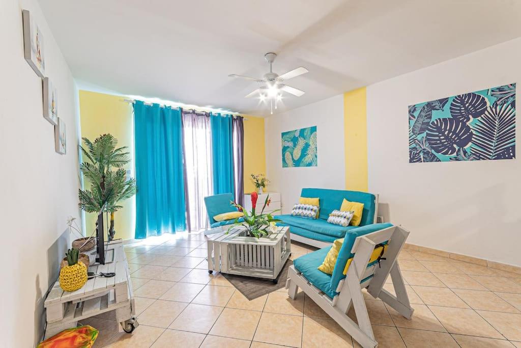 sala de estar con sillas azules y sofá en Gwad'AZUR - séjour tout confort en Guadeloupe en Le Gosier