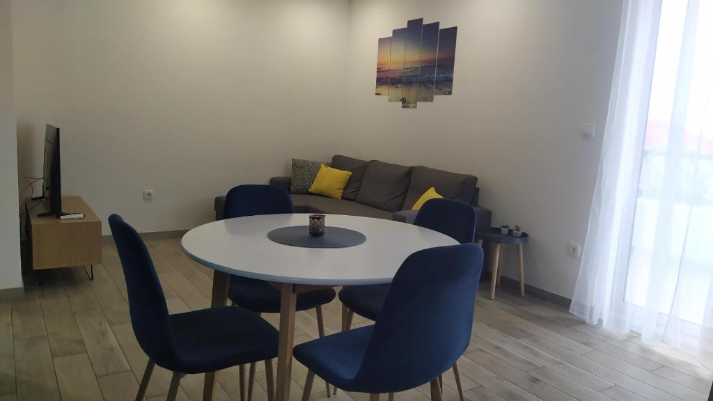 een woonkamer met een tafel en stoelen en een bank bij Urban Apartment Vukić in Trogir