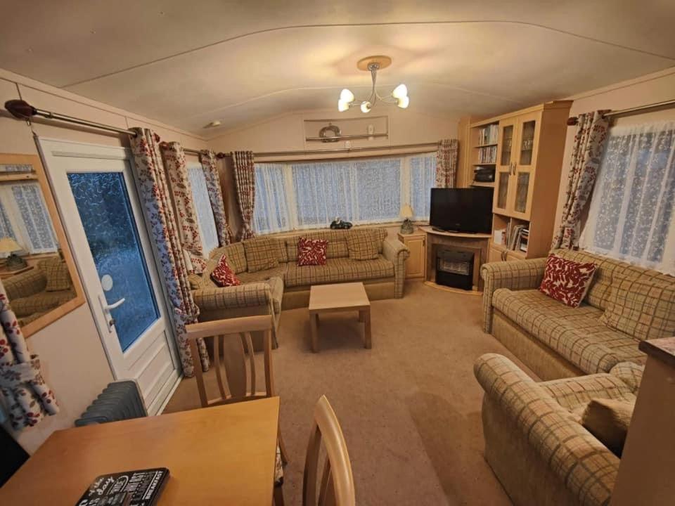 a large living room with couches and a table at MILLFIELDS AT INGOLDMELLS, Skegness in Tattershall