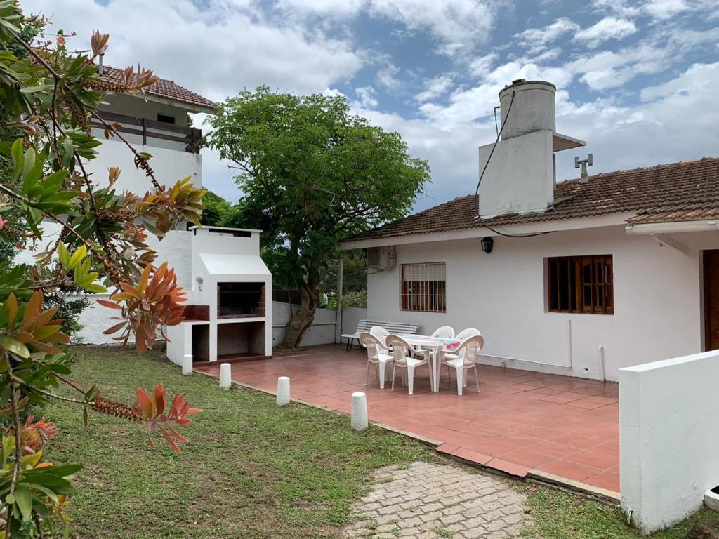 eine Terrasse mit Tisch und Stühlen vor einem Haus in der Unterkunft Casa Elena in Villa Gesell