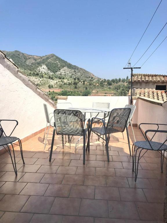 a patio with a table and chairs on a roof at Casa Lola Beceite, terraza, barbacoa y chimenea in Beceite