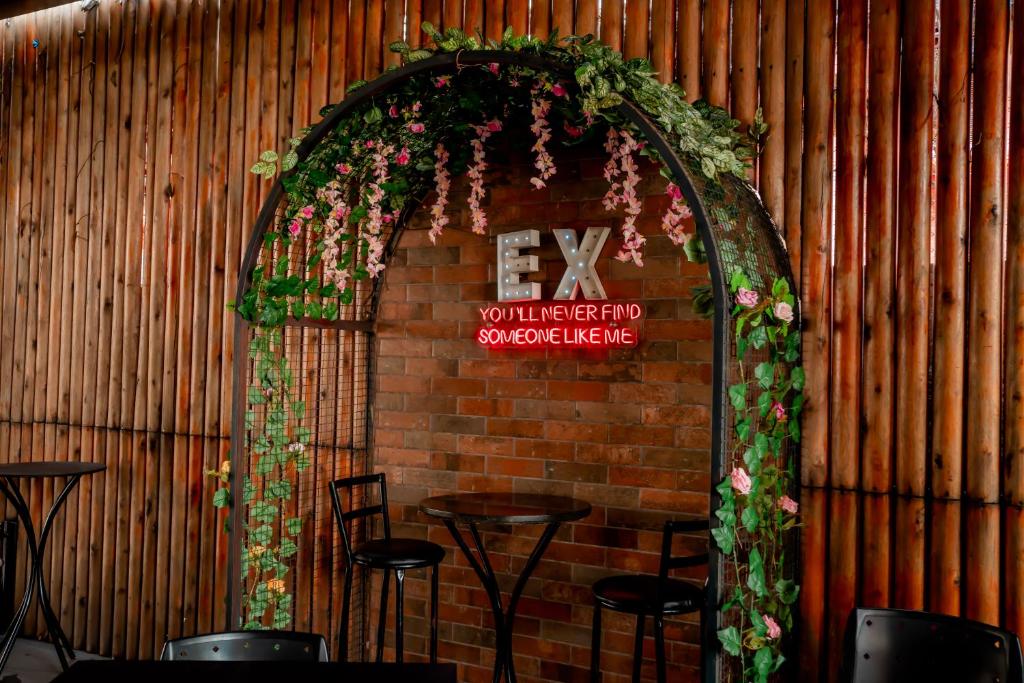 a brick wall with an arch with flowers and plants at Megal Suites Hotel in Ciudad del Este