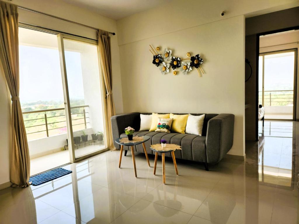 uma sala de estar com um sofá e uma mesa em Trinity Stays Nashik - Mountain view apartment close to Sula em Nashik