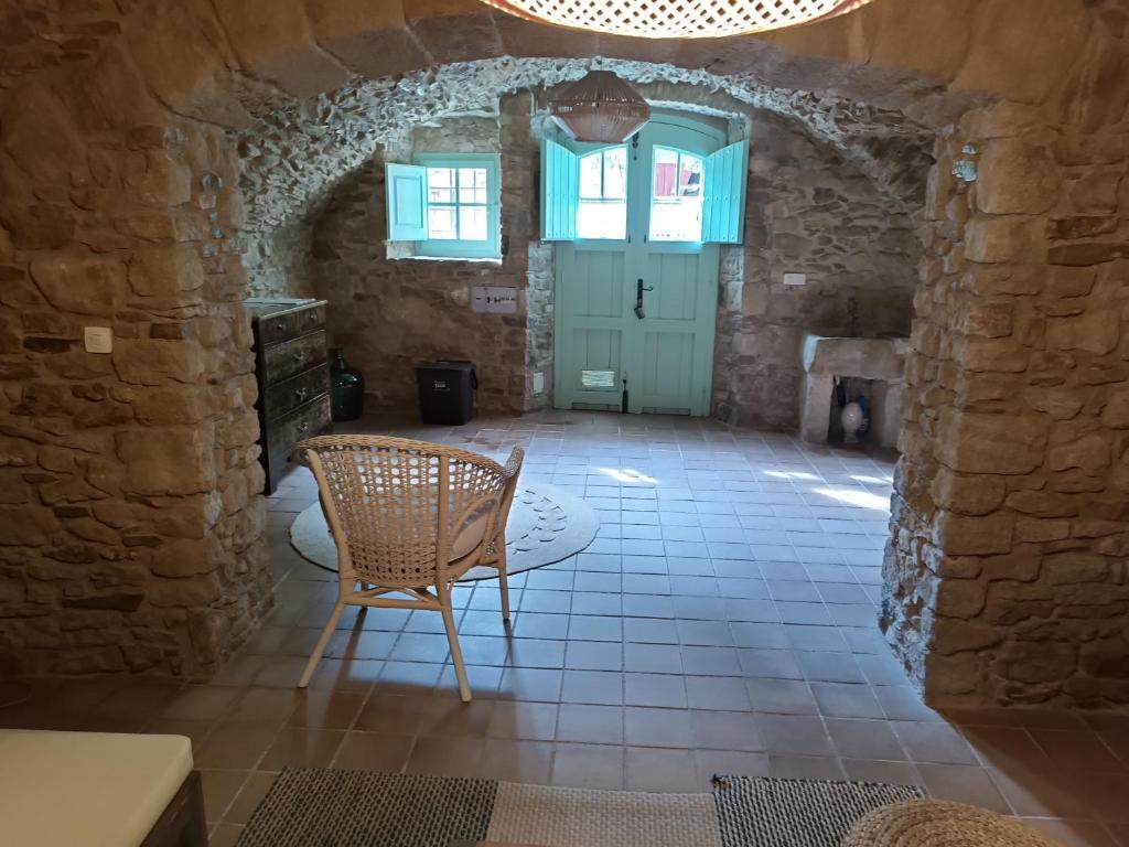 ein Zimmer mit einem Stuhl und einem Tisch in einem Gebäude in der Unterkunft Casa Peratallada in Peratallada