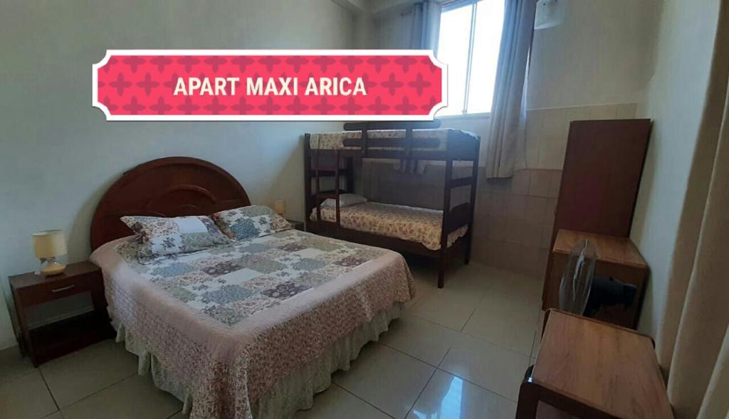 a bedroom with a bed and a sign that readsark mainzona at Apart Maxi in Arica