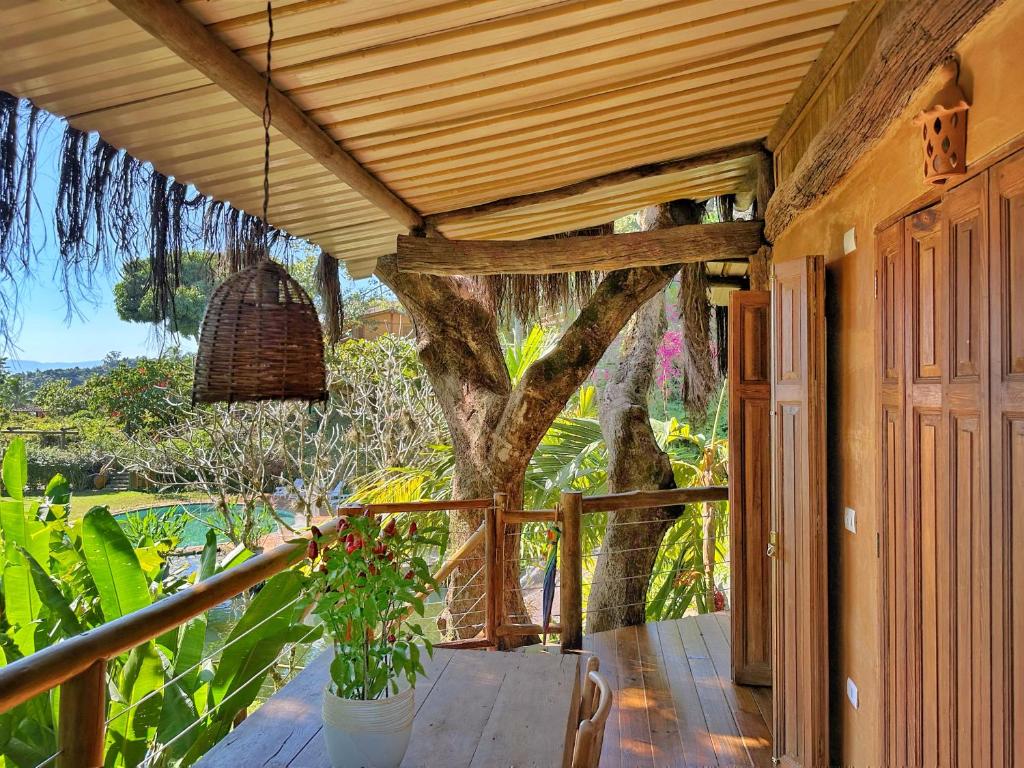 a porch of a house with a tree at Casas D’Água Doce - Casa da Árvore in Ilhabela