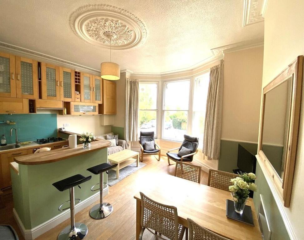 cocina y sala de estar con mesa y sillas en Lovely Victorian Apartment in Clifton Village, en Bristol