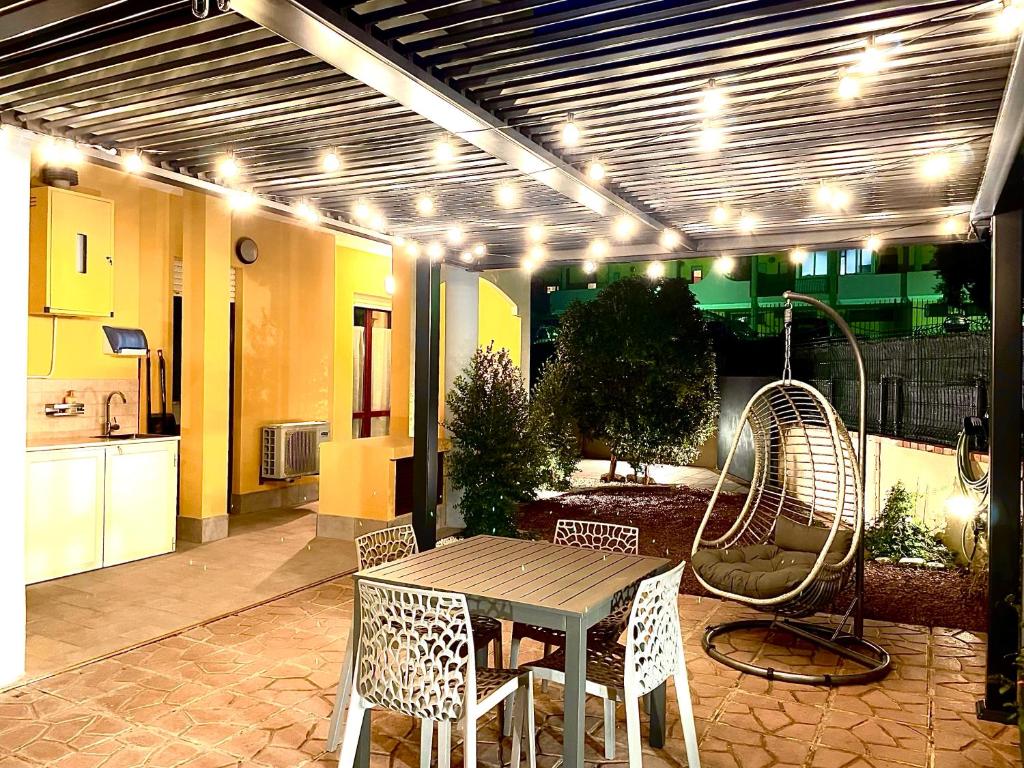 Il dispose d'une cuisine et d'une terrasse avec une table et des chaises. dans l'établissement Dimora Quartello, à Quartu SantʼElena