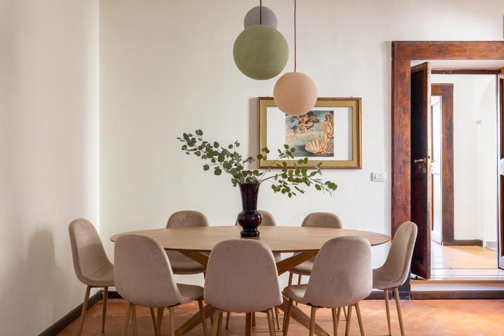 een eetkamer met een houten tafel en stoelen bij iFlat Trevi Fountain's roomy&friendly apartment in Rome