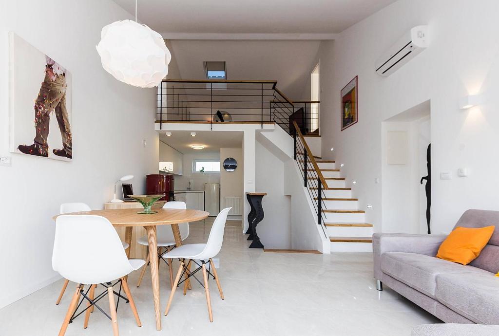 a living room with a table and white chairs at Apartments Dada in Biograd na Moru