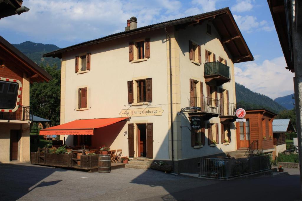 un grand bâtiment blanc avec un toit rouge dans l'établissement La Petite Auberge, à Versegeres 