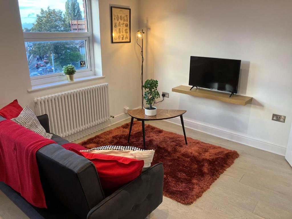 a living room with a couch and a table and a tv at Magnificent Refurbished 1 Bed Flat few steps to High St ! - 4 East House in Epsom