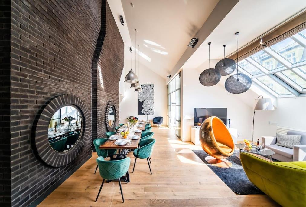 a dining room with a brick wall and a table and chairs at 5BR+2Bath Old Town Industrial Penthouse, A/C in Prague