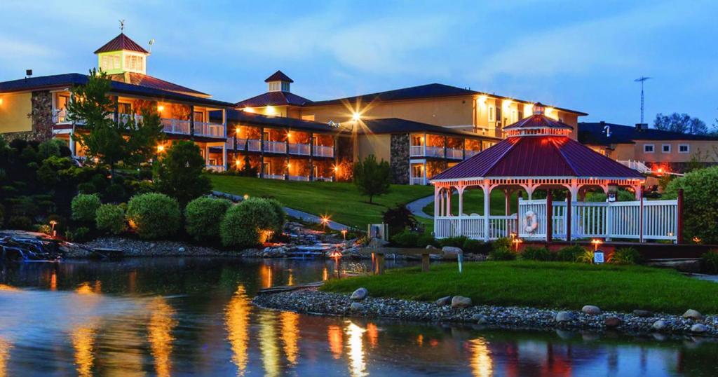 a large building with a gazebo next to a river at Berlin Resort in Millersburg