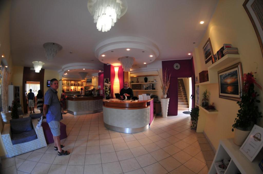 a man is standing in a restaurant lobby at Hotel Antonella in Lido di Classe