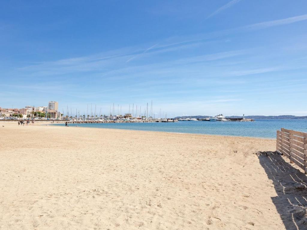 a view of the beach with a pier in the background at Apartment La Palmeraie II-1 by Interhome in Sainte-Maxime