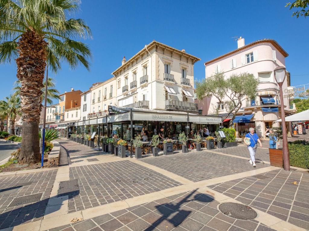 a street with a group of people sitting in chairs at Apartment La Palmeraie II-1 by Interhome in Sainte-Maxime