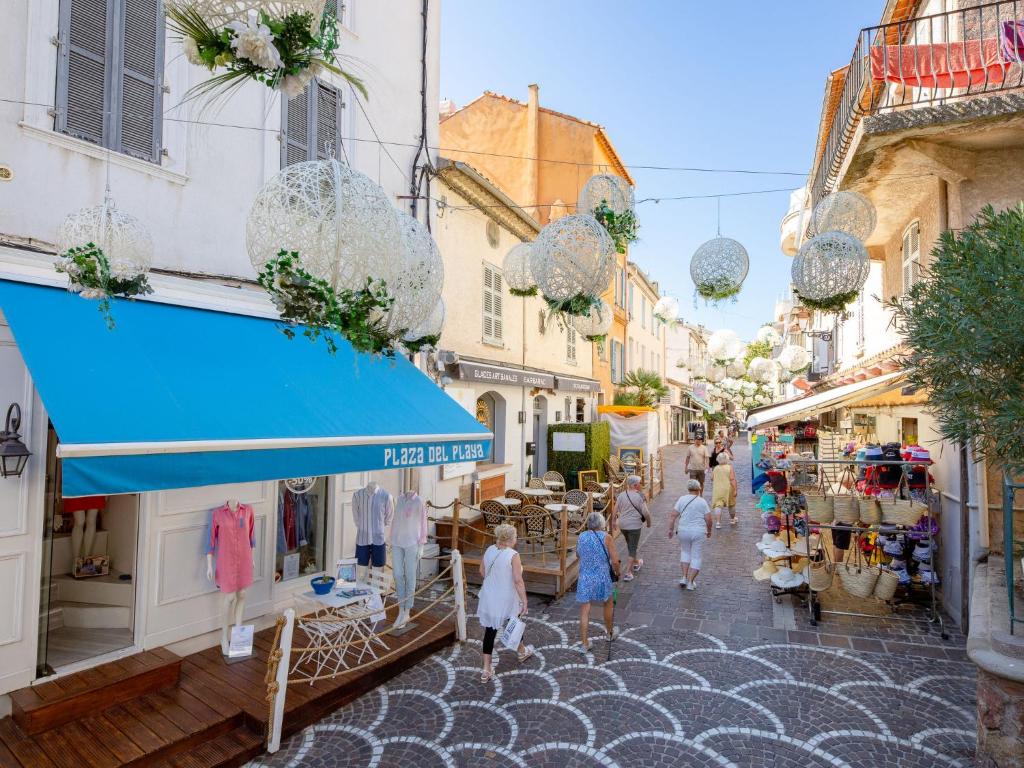 a group of people walking down a street at Holiday Home La Bastide Rose by Interhome in Sainte-Maxime