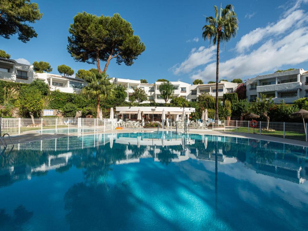 una piscina in un resort con palme e edifici di Apartment Jardin de miraflores by Interhome a Mijas Costa
