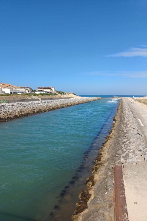 a canal of water next to a beach at Apartment L&#39;Oustalet-3 by Interhome in Mimizan-Plage