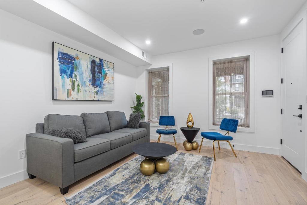 a living room with a gray couch and blue chairs at Capitol View2 Townhouse Condo in Washington