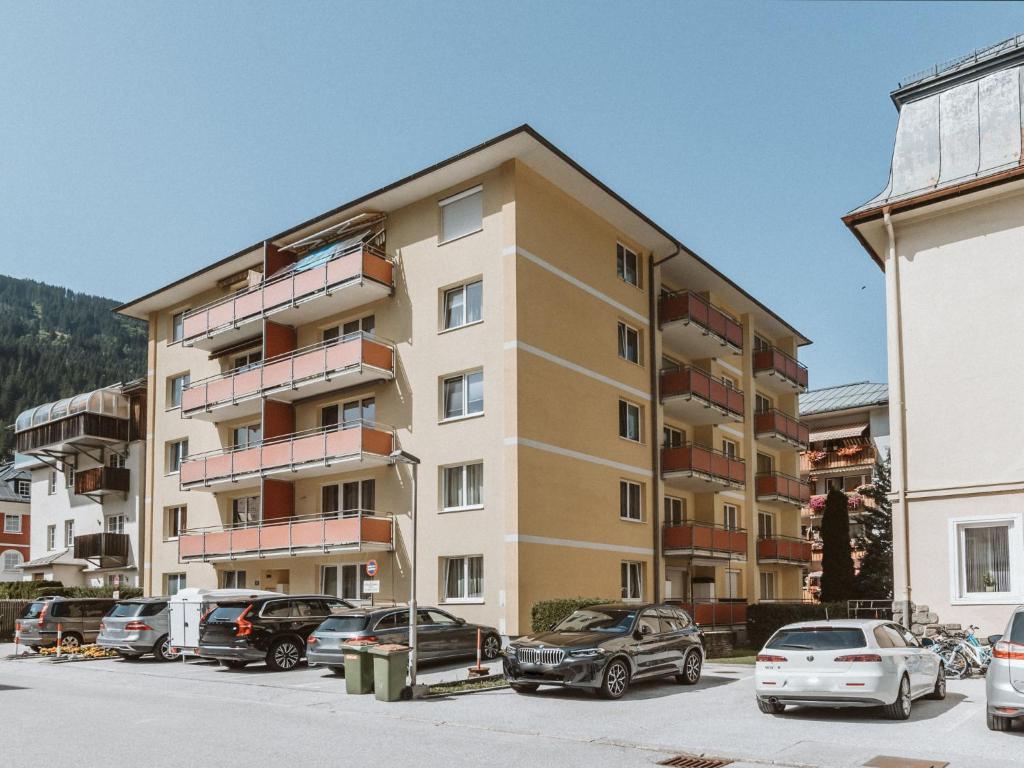 un gran edificio de apartamentos con coches aparcados en un aparcamiento en Apartment Stubner Kogel Top 18 by Interhome, en Bad Gastein