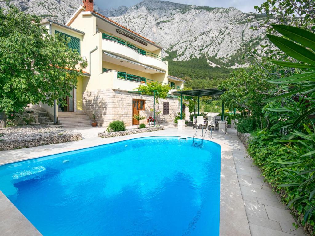 a swimming pool in front of a house with a mountain at Holiday Home Drago by Interhome in Veliko Brdo