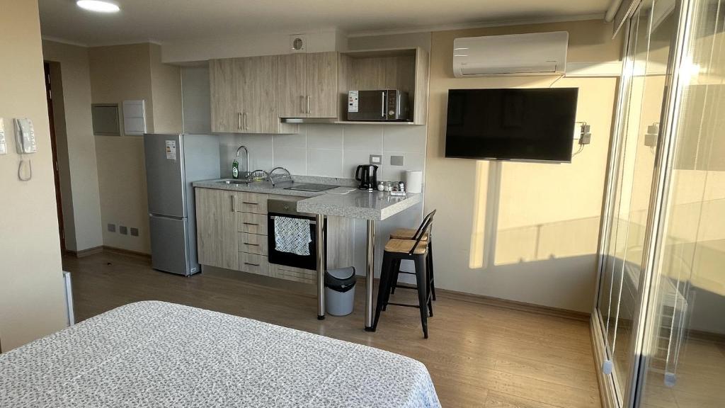 a small kitchen with a sink and a counter at Depto central, parking, moderno in Chillán