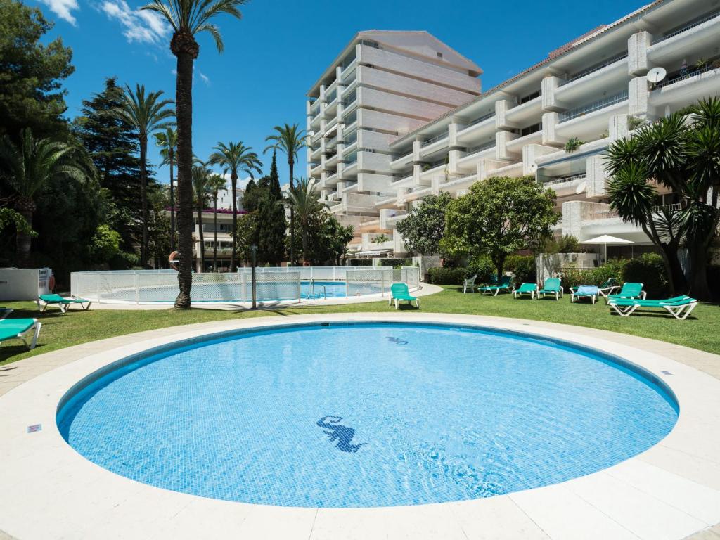 a large swimming pool in front of a large building at Apartment Jardines Del Mar by Interhome in Marbella