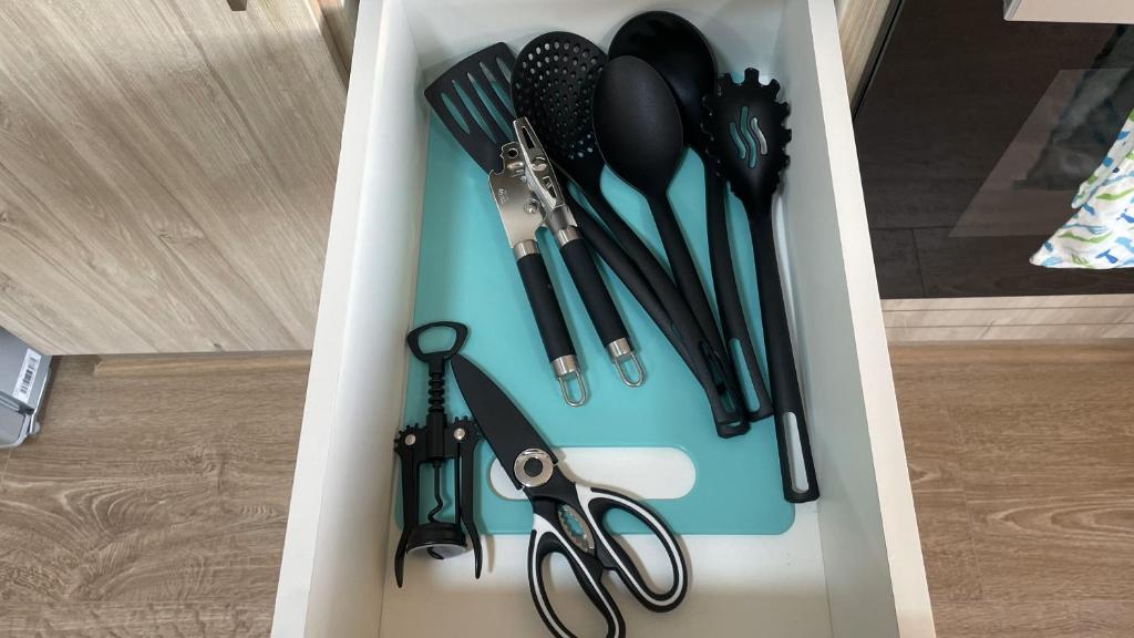 a tray with cooking utensils and a pair of scissors at Depto central, parking, moderno in Chillán