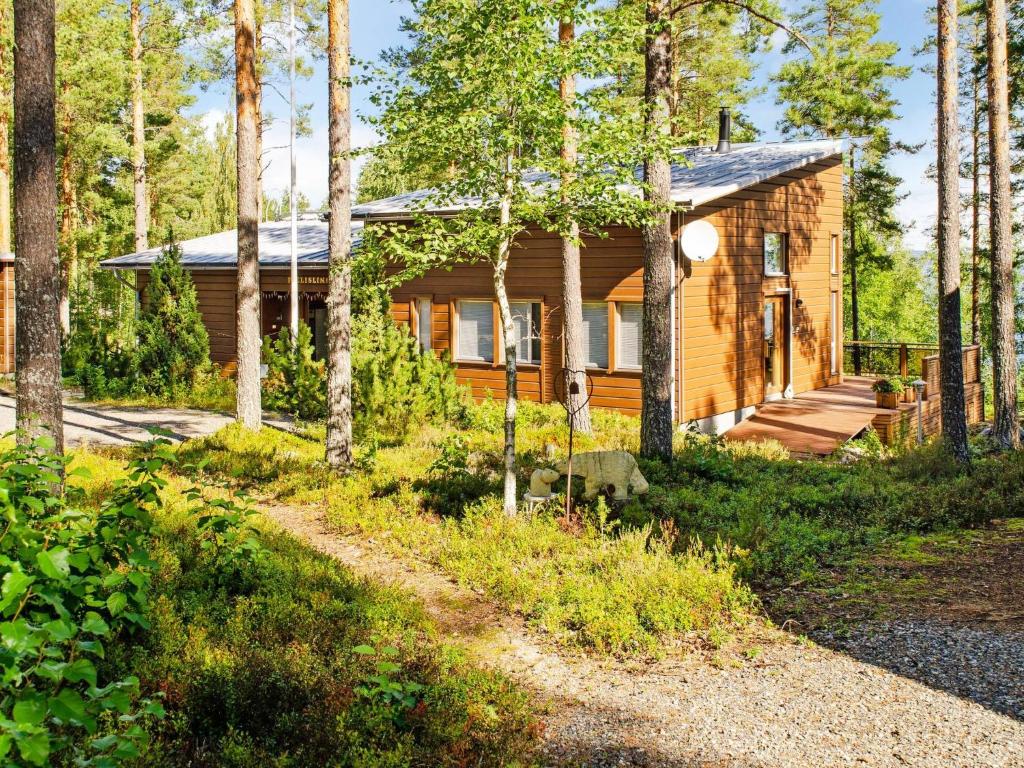 eine Blockhütte im Wald mit einem Pfad davor in der Unterkunft Holiday Home Pielislinna-loma-koli by Interhome in Kolinkylä