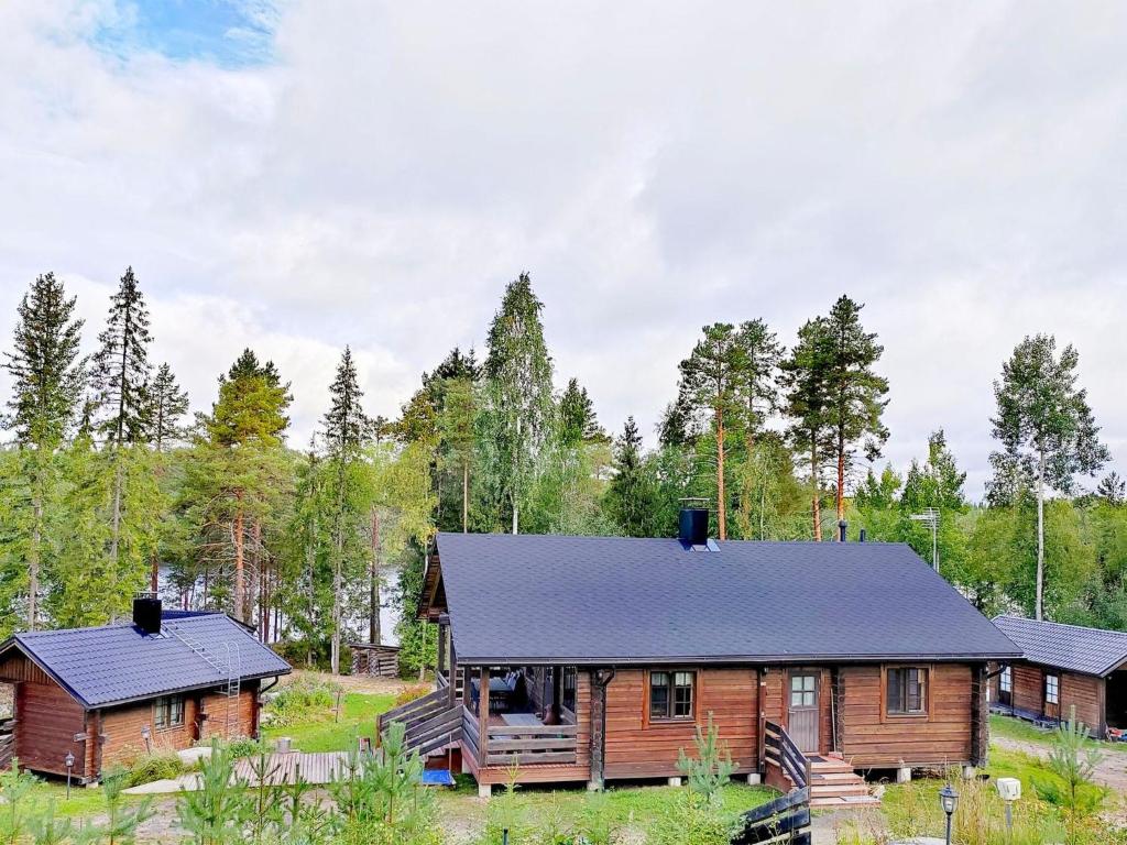 drewniany domek w lesie z czarnym dachem w obiekcie Holiday Home Iltaranta by Interhome w mieście Jyväskylä