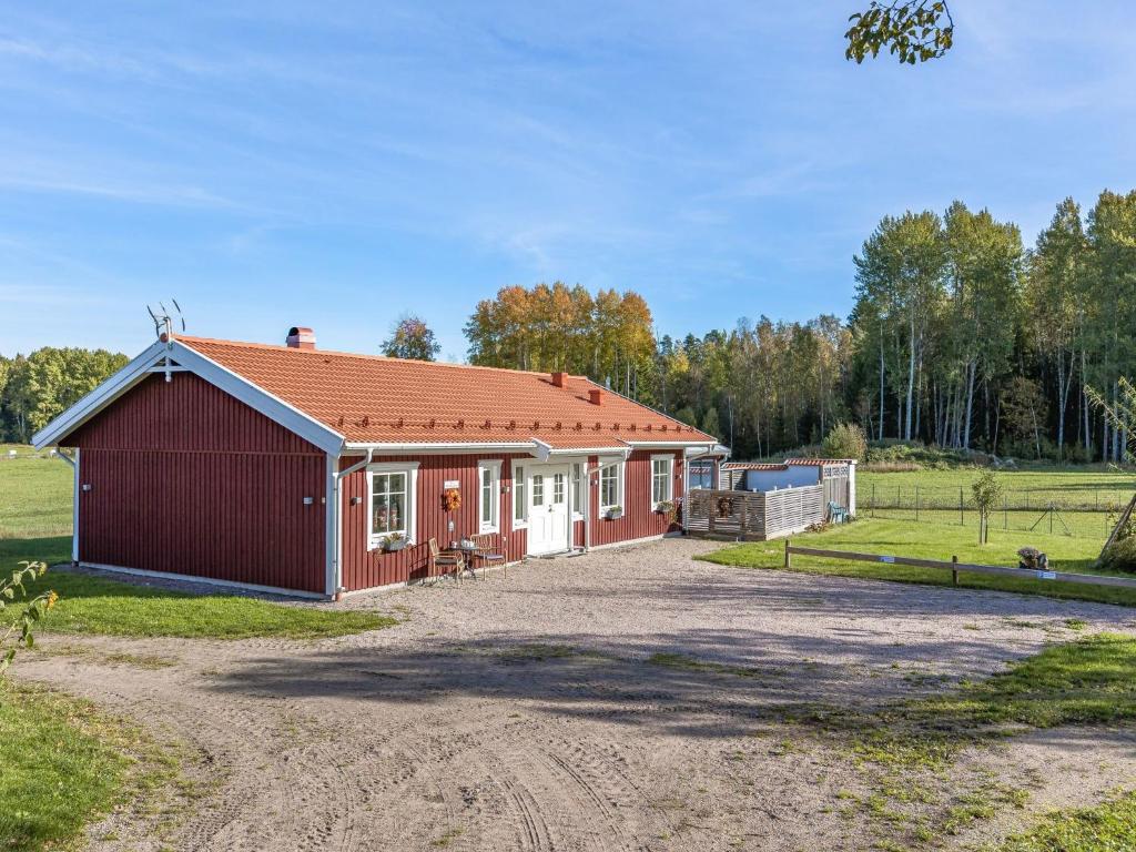 un petit bâtiment rouge avec une allée en gravier dans l'établissement Holiday Home Villa Blommelund by Interhome, à Kolmården