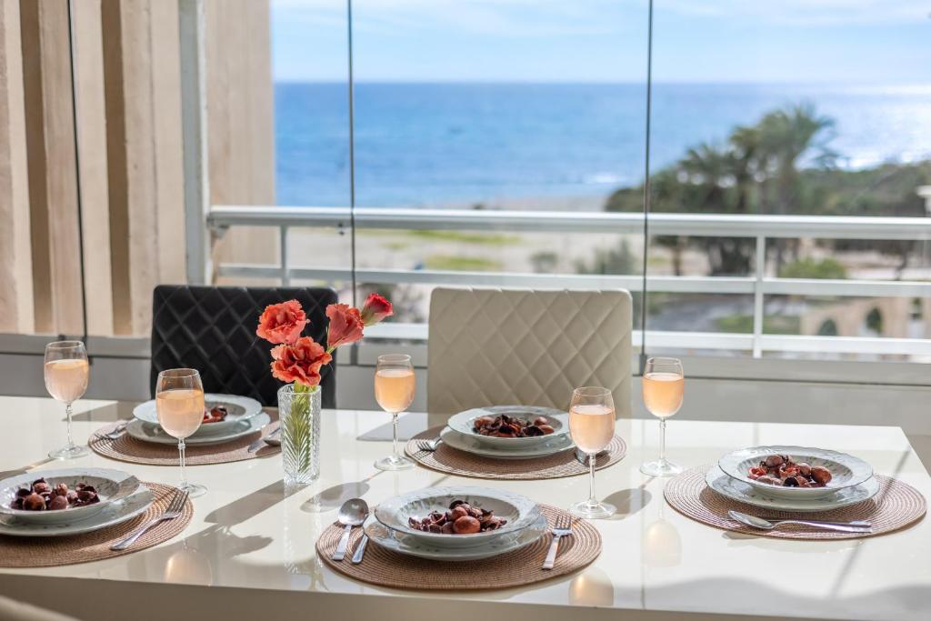une table avec des assiettes de nourriture et une vue sur l'océan dans l'établissement Fidalsa Bella Vista, à El Campello