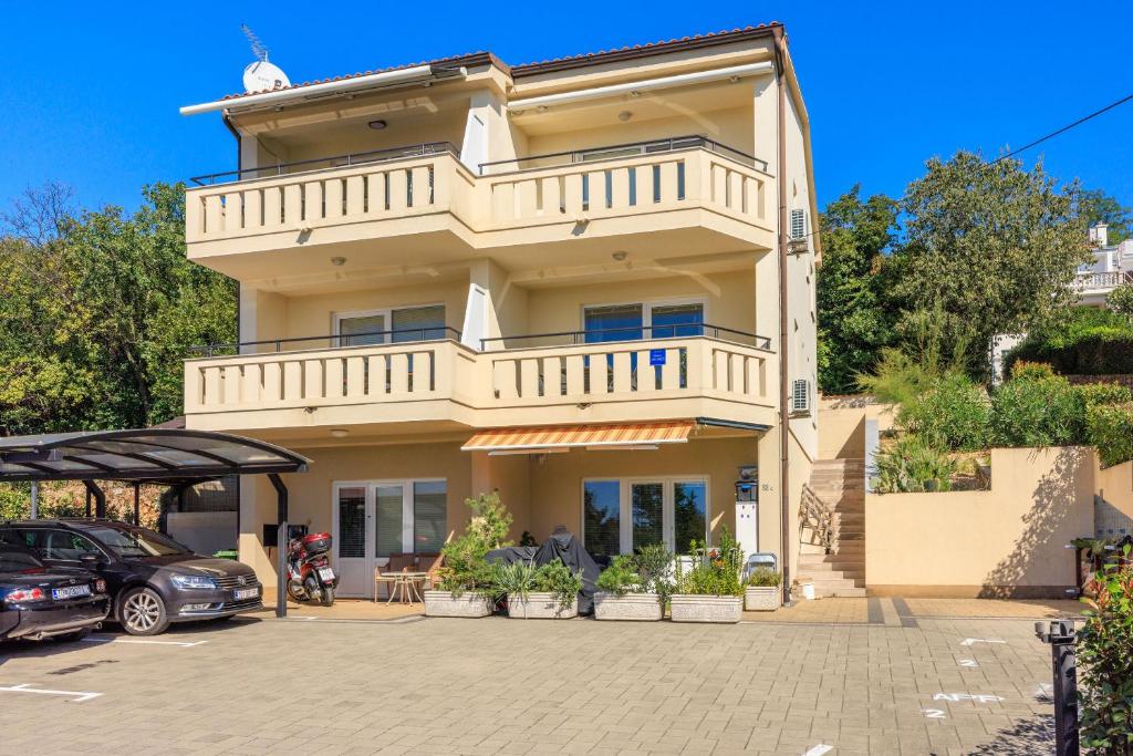 a large house with a balcony on top of it at Apartments Petak Novi in Dramalj