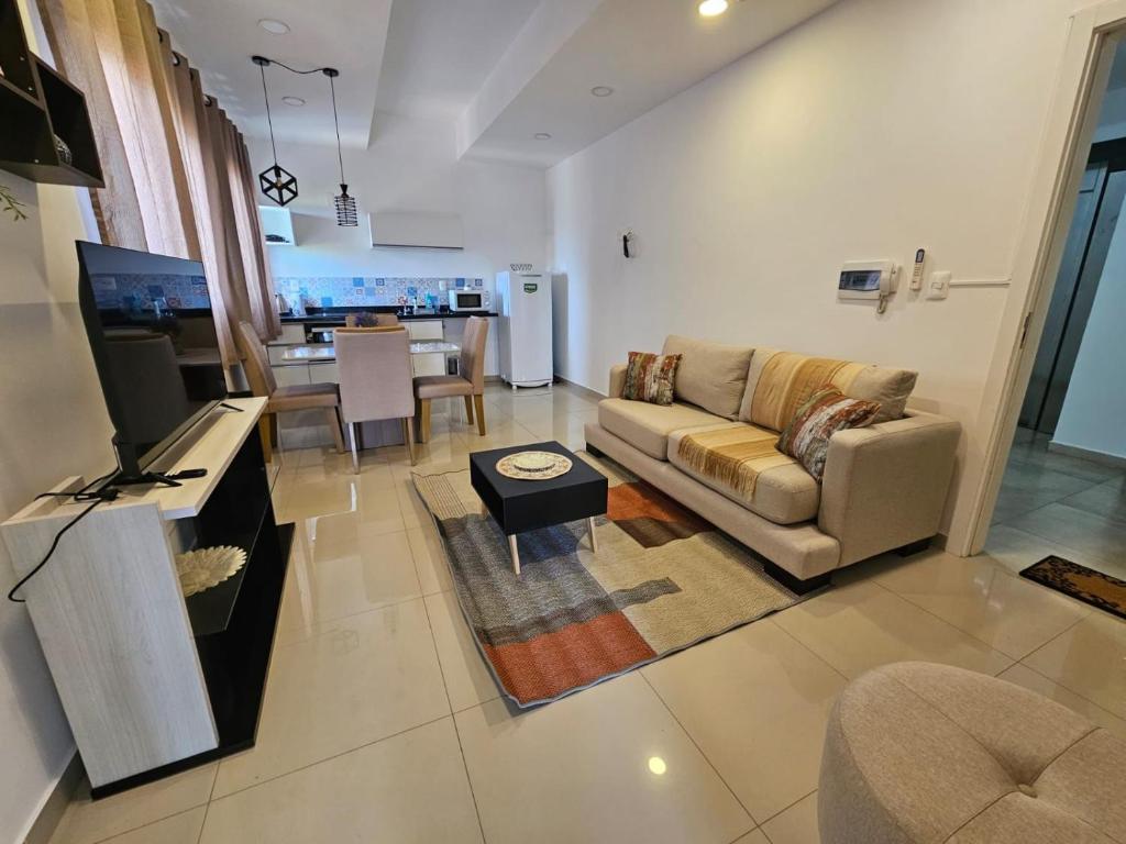 sala de estar con sofá y mesa en Apartamento confortable, en Ciudad del Este