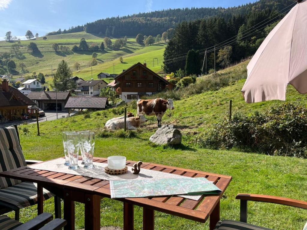 a picnic table with a cow in a field at Apartment Sonnenblick II by Interhome in Büreten
