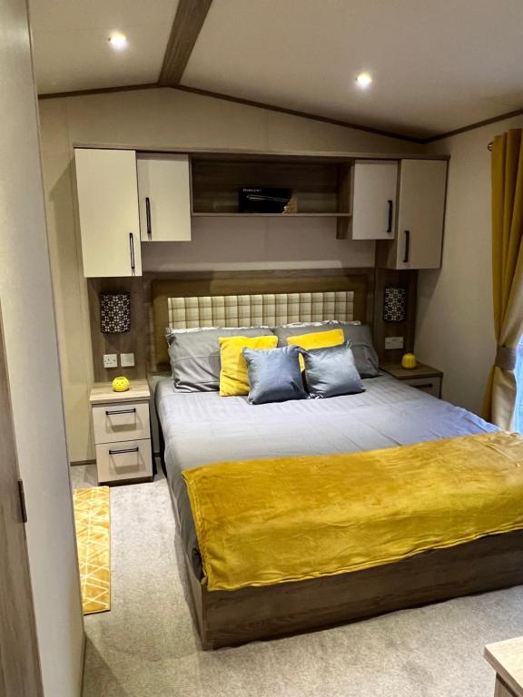 a bedroom with a large bed with yellow and blue pillows at Sun sea and sand at Whitley bay in Hartley