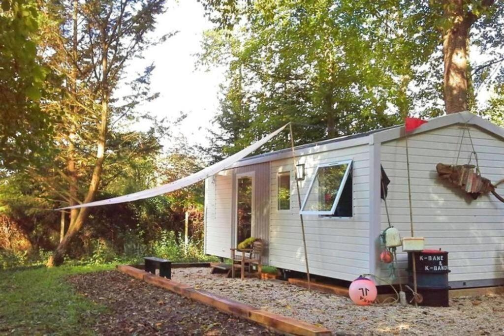 ein weißes winziges Haus mitten im Garten in der Unterkunft La Cabane du Pêcheur à 10min de Disneyland Paris - Cabane & Cabanon in Chalifert