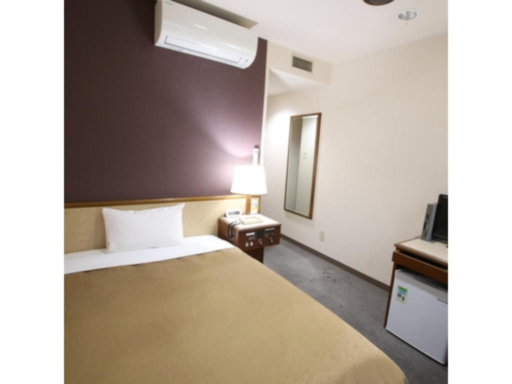 Habitación de hotel con cama y espejo en Hotel Aston Hotel Osaka Sakai - Vacation STAY 97512v, en Sakai