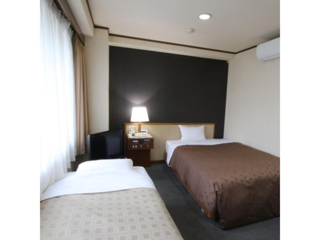 a hotel room with two beds and a black wall at Hotel Aston Hotel Osaka Sakai - Vacation STAY 97562v in Sakai
