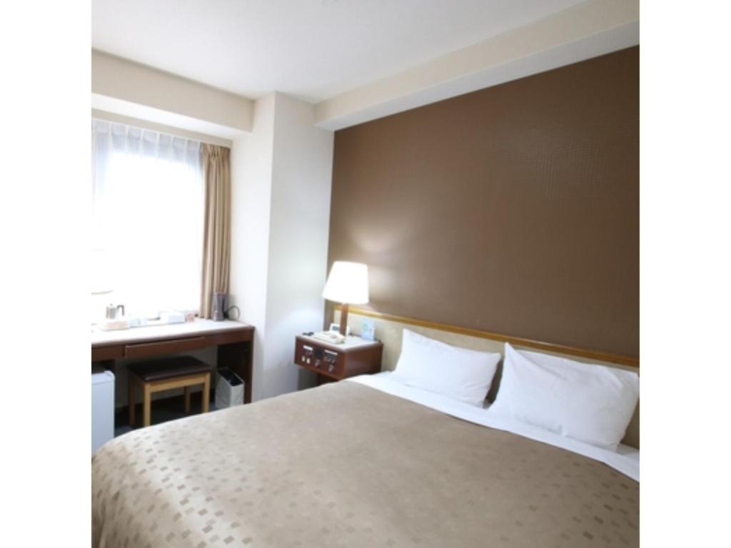 a bedroom with a bed and a desk and a window at Hotel Aston Hotel Osaka Sakai - Vacation STAY 97559v in Sakai