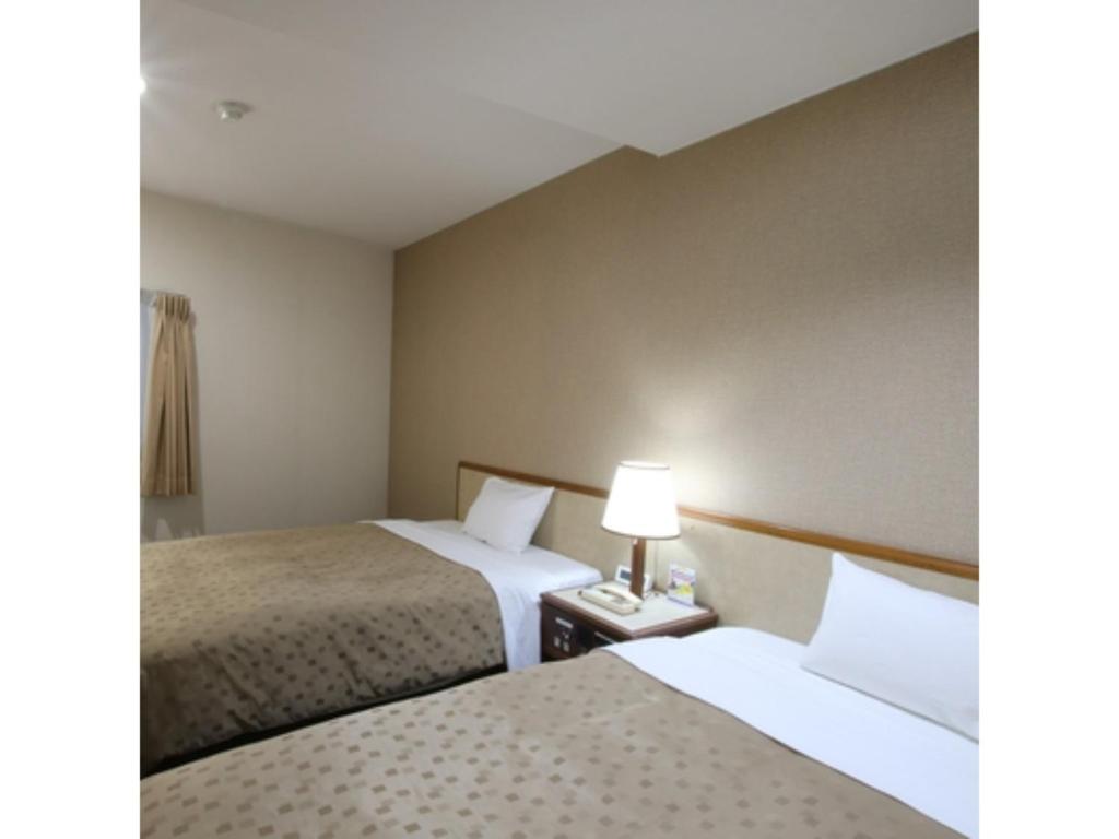 a hotel room with two beds and a lamp at Hotel Aston Hotel Osaka Sakai - Vacation STAY 97577v in Sakai