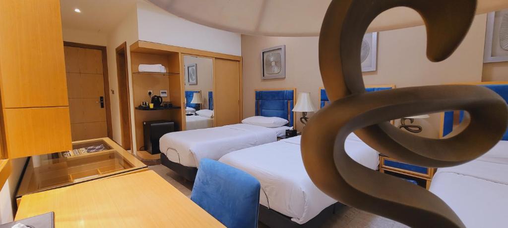 a hotel room with two beds and a statue of a symbol at Al Sahla Land Hotel in An Najaf