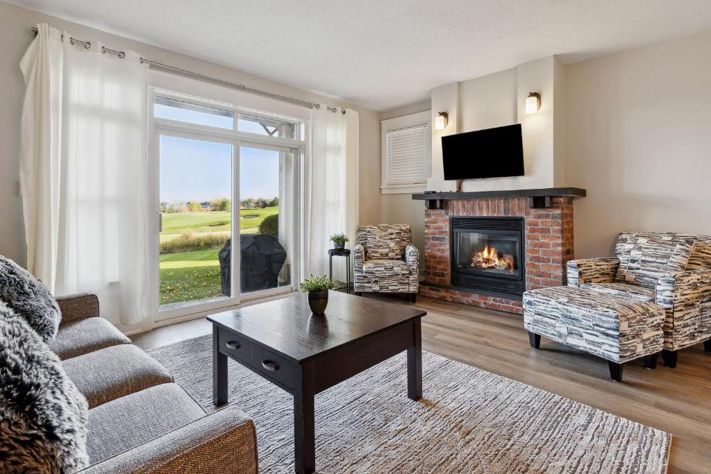 Una sala de estar con chimenea y televisión. en 2 Bedroom Condo only steps to the Village!, en Blue Mountains