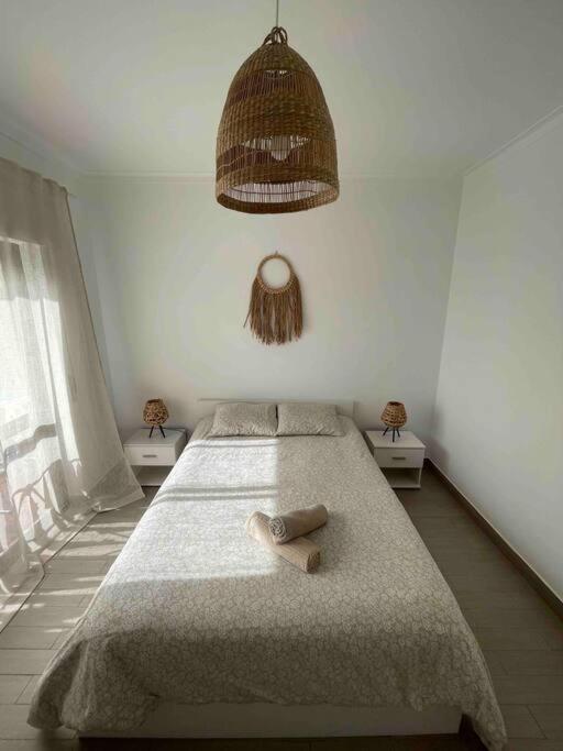 ein Schlafzimmer mit einem Bett und einem Handtuch darauf in der Unterkunft Casa Carvalho in Quinta do Conde