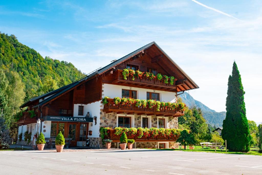 un bâtiment avec des boîtes de fleurs à l'avant dans l'établissement Apartments in Villa Flora, à Kranjska Gora