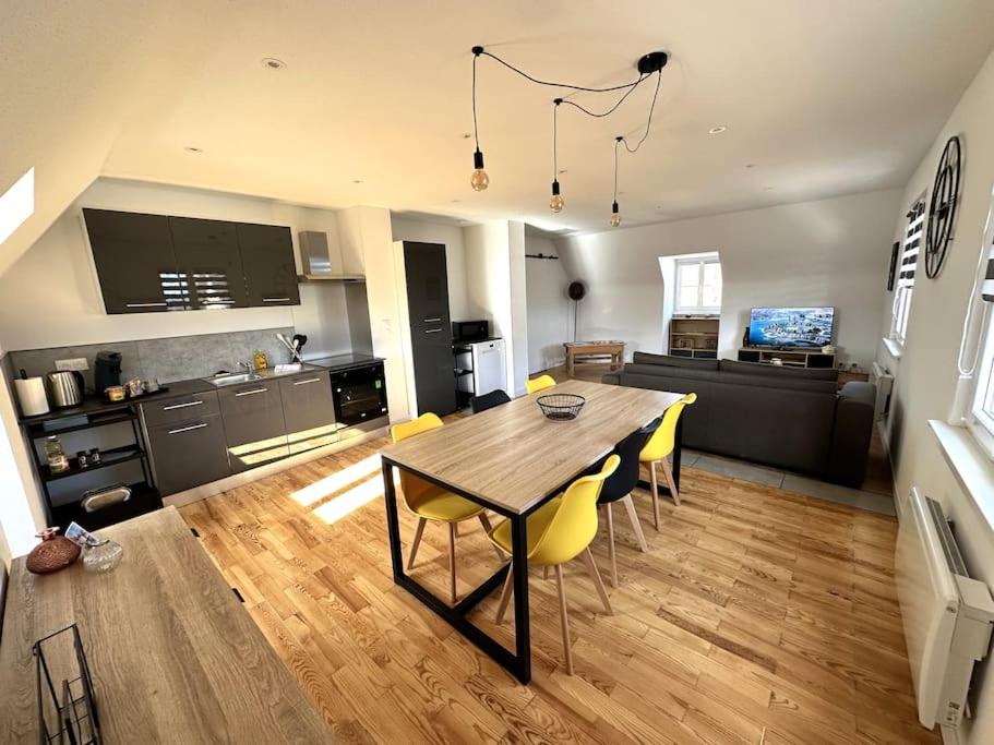 cocina y sala de estar con mesa de madera y sillas en * Nouveauté * Gîte Manala en Bennwihr