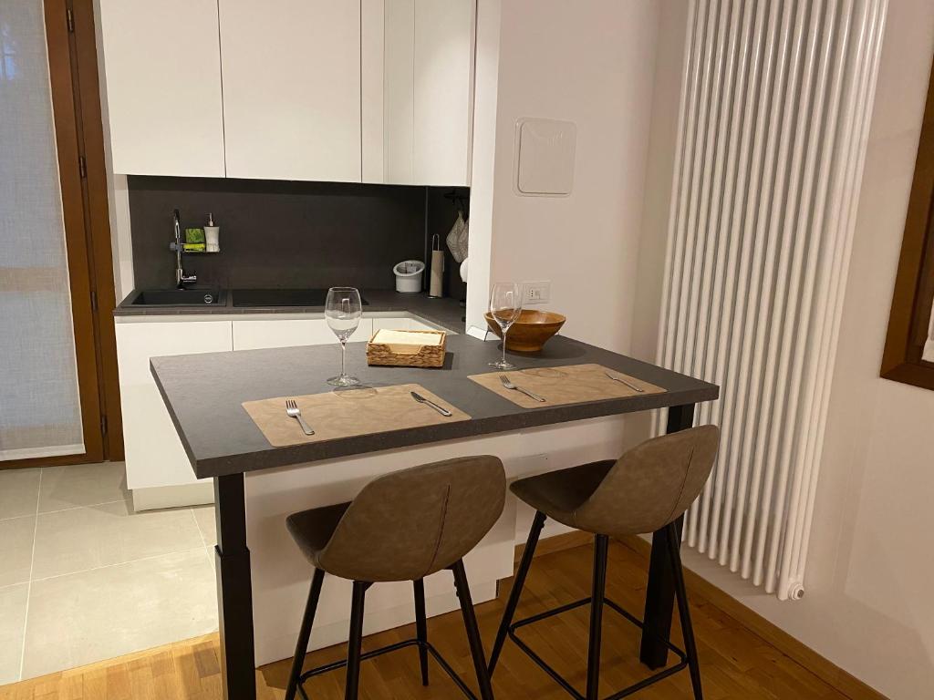 una cucina con bancone, due sedie e un tavolo di Appartamento Galilei a Udine