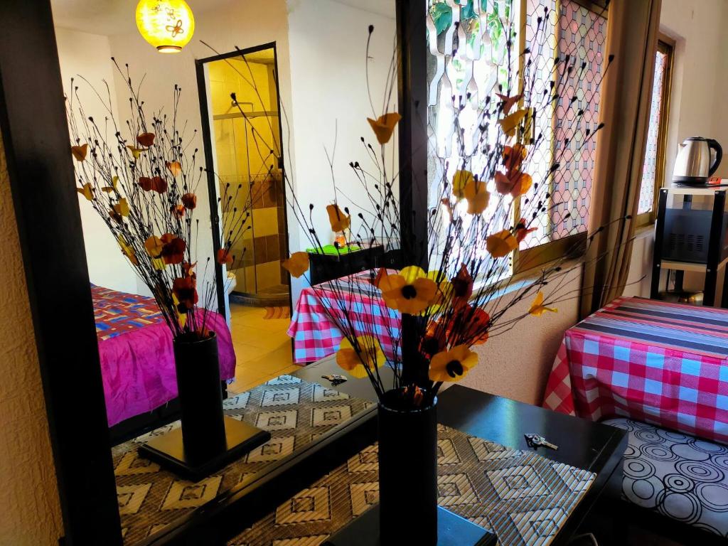 a room with a mirror and two vases with flowers at Apartamento Centricovive El Pulsar De La Ciudad in Toluca